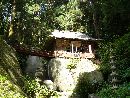 厳島神社境内から見上げた社殿と石造多層塔と石燈篭
